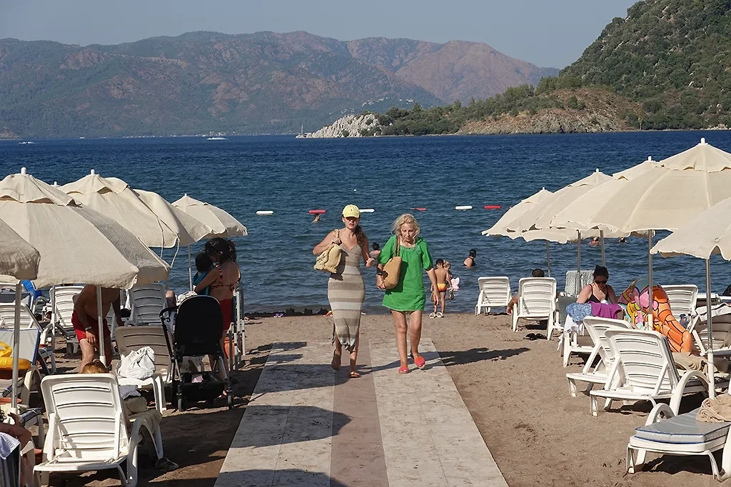 Со своим ковриком и зонтом можно перемещаться по разным пляжам. Фото © ТАСС 