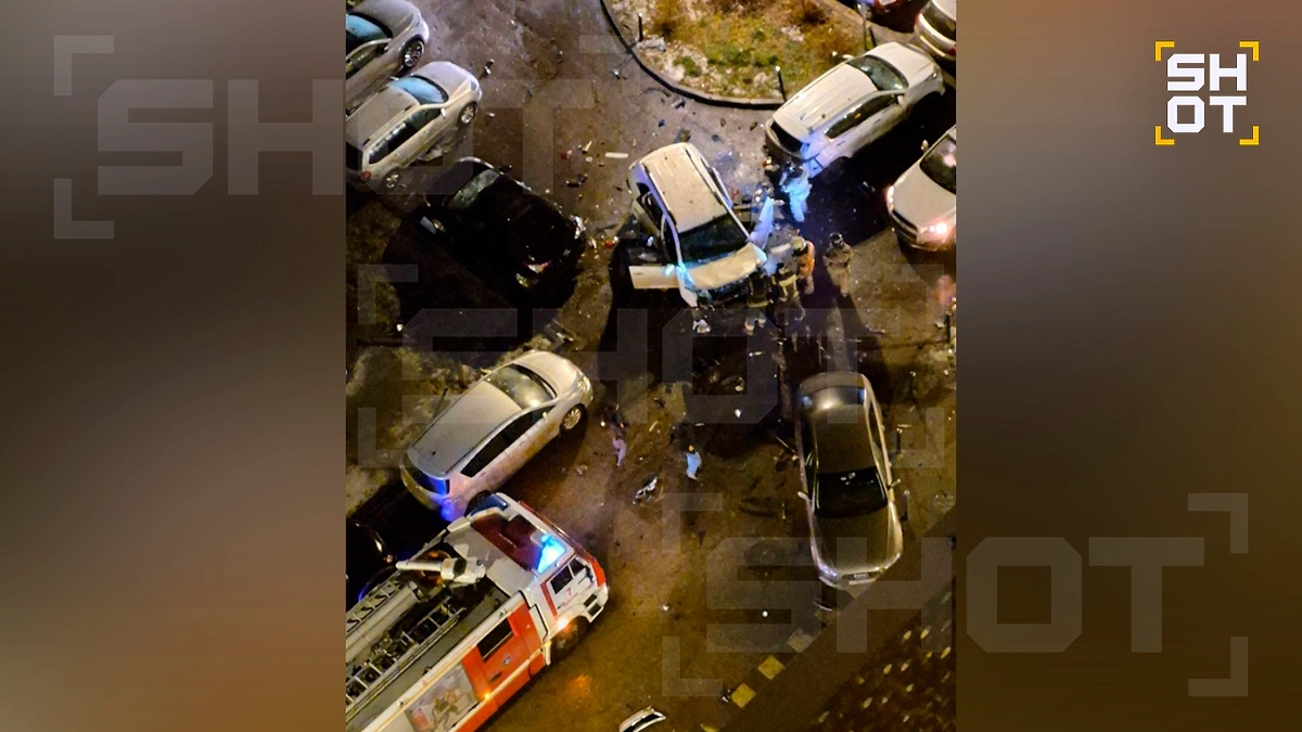 Спасатели эвакуируют водителя из машины, которая взорвался на парковке в Москве. Фото © SHOT